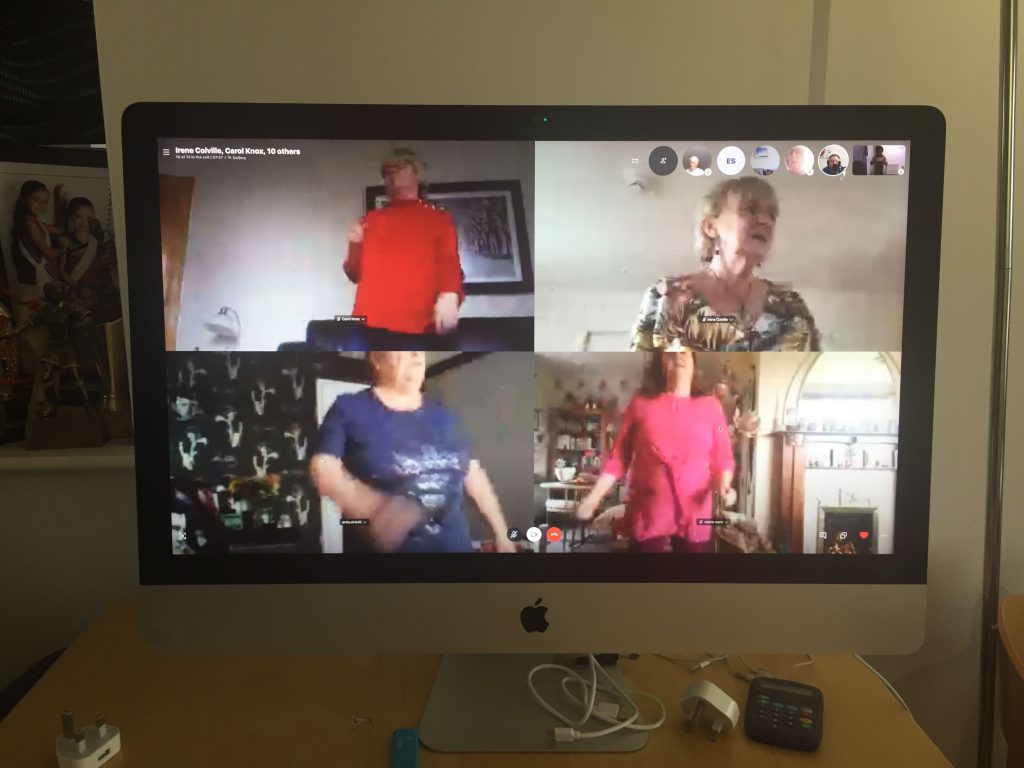 Photo of Zoom session with four screens: with women dancing in their homes